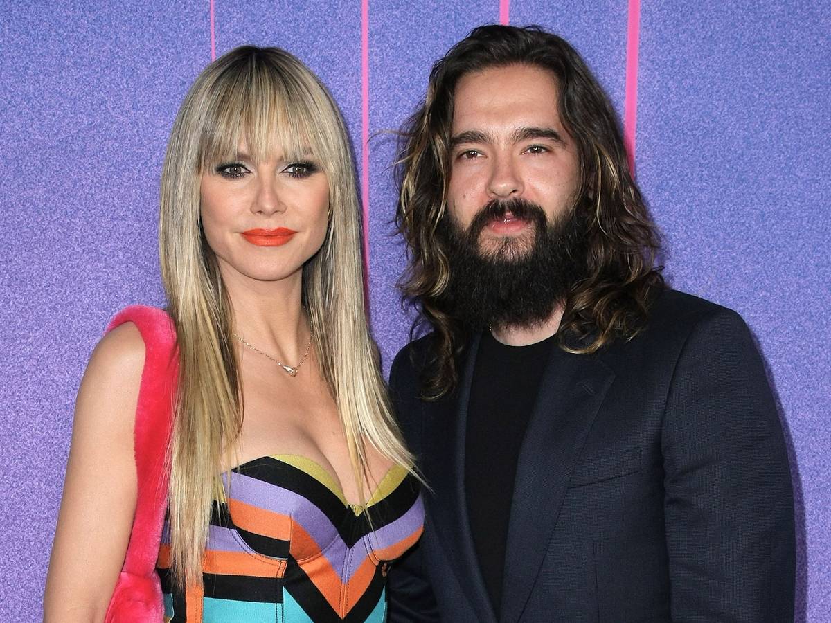 Heidi Klum und Tom Kaulitz posieren gemeinsam für die Kameras. Sie trägt ein mehrfarbiges Kleid, er ein schwarzes Shirt mit dunklem Jackett.