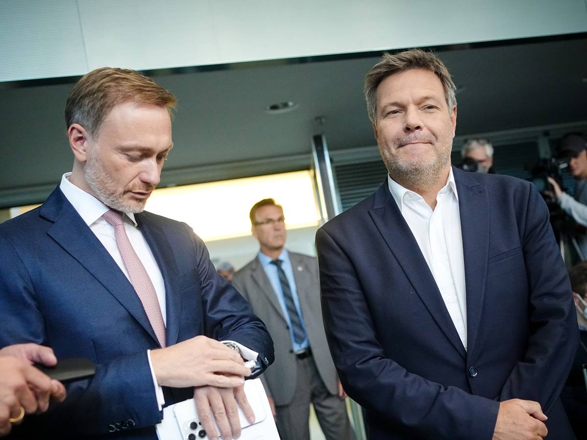 Christian Lindner (FDP, l), Bundesminister der Finanzen, blickt neben Robert Habeck (Bündnis 90/Die Grünen), Bundesminister für Wirtschaft und Klimaschutz, zu Beginn der Pressekonferenz zur Vorstellung der Pläne der Bundesregierung zur Energieversorgung und Preisbegrenzung für Gas auf die Uhr.