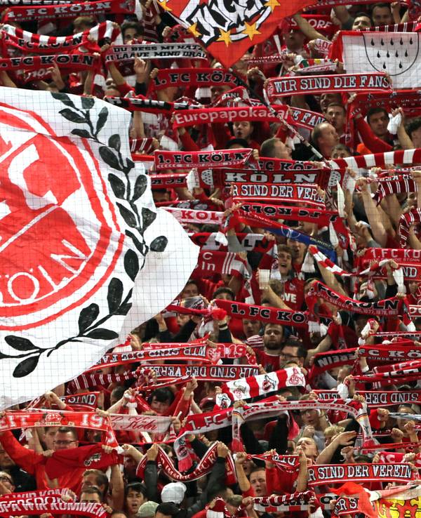 Auf der Südtribüne des 1.FC Köln werden Schals in die Höhe gehalten