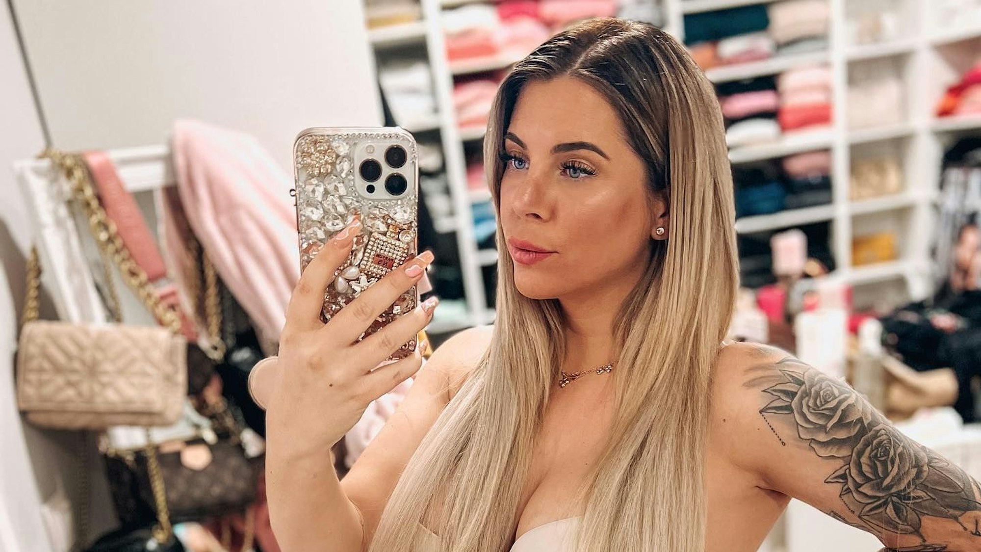 Jenny posiert mit ihrem Babybauch für ein Selfie vor einem Spiegel.