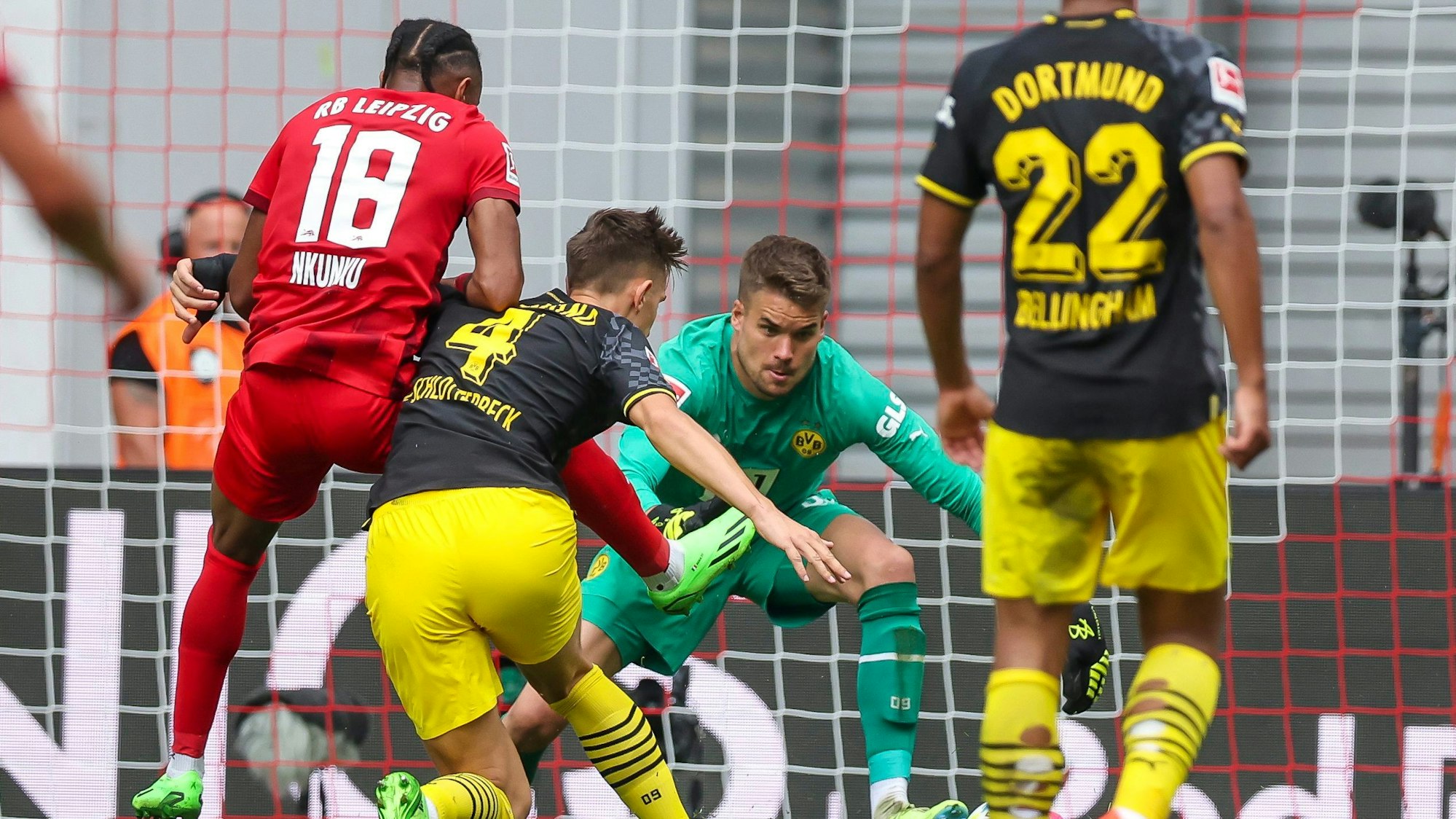 Dortmunds Torwart Alexander Meyer (2.v.r) und Nico Schlotterbeck klären gegen Leipzigs Christopher Nkunku (l).