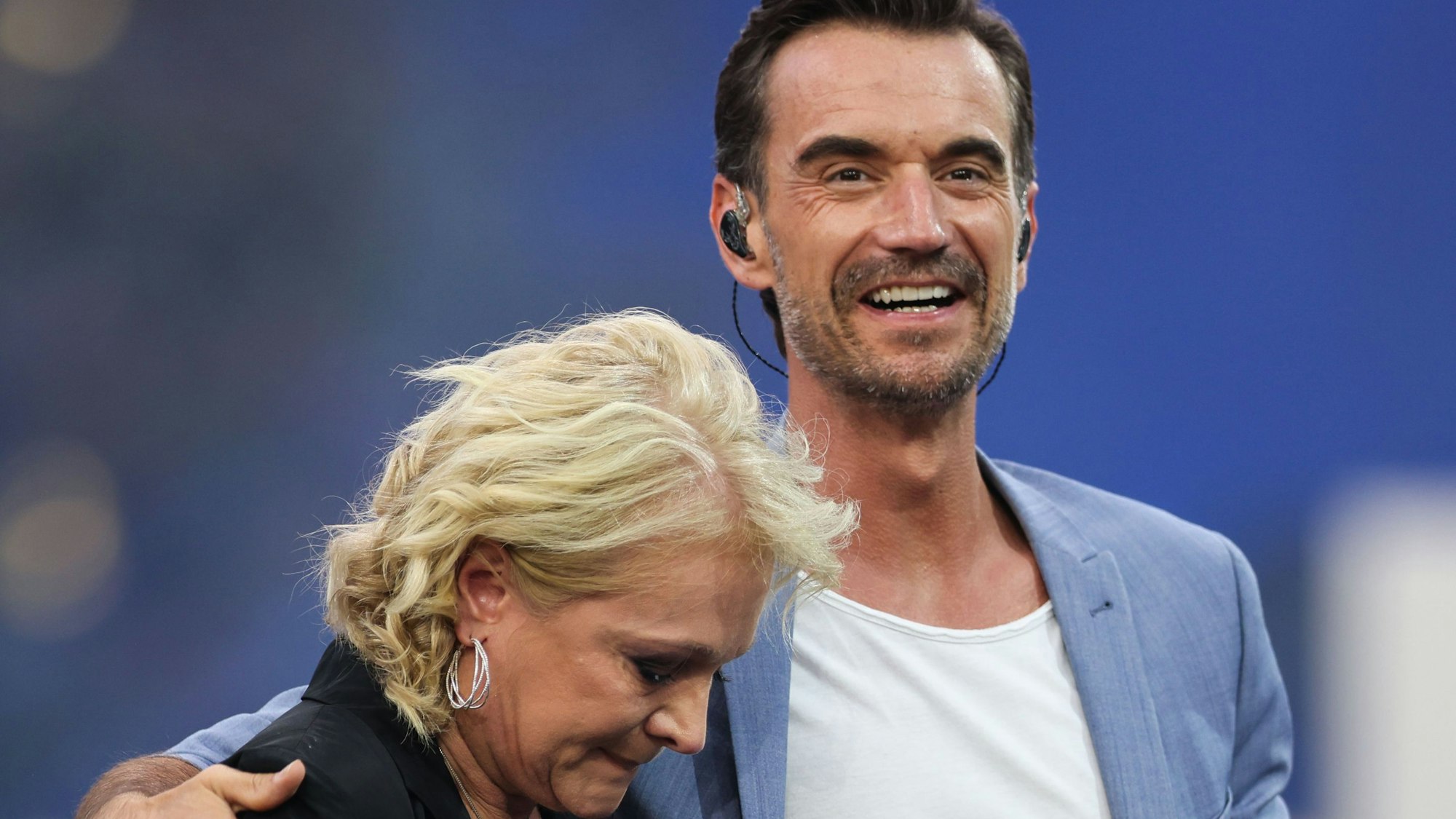 Moderator Florian Silbereisen und Schlagersängerin Nicole auf der Bühne. Florian nimmt die Sängerin in den Arm.