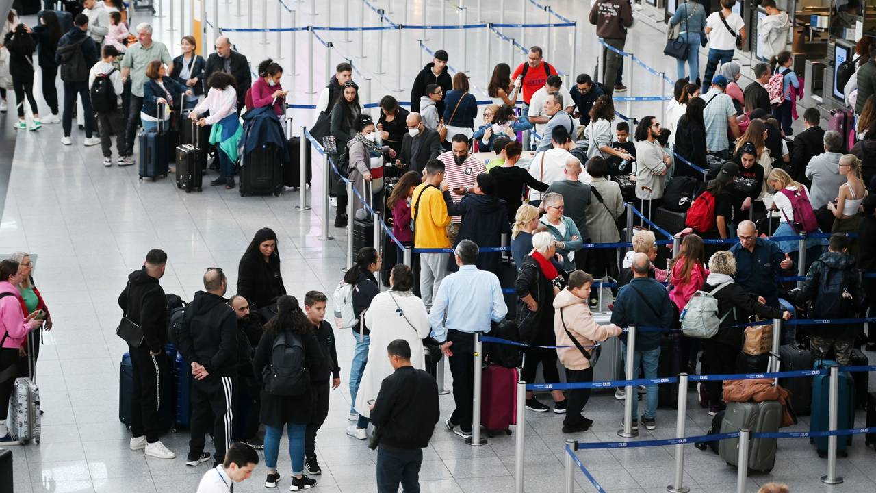 Reisende des Düsseldorfer Flughafens stehen in der Abflugshalle an den Schaltern in Schlangen.