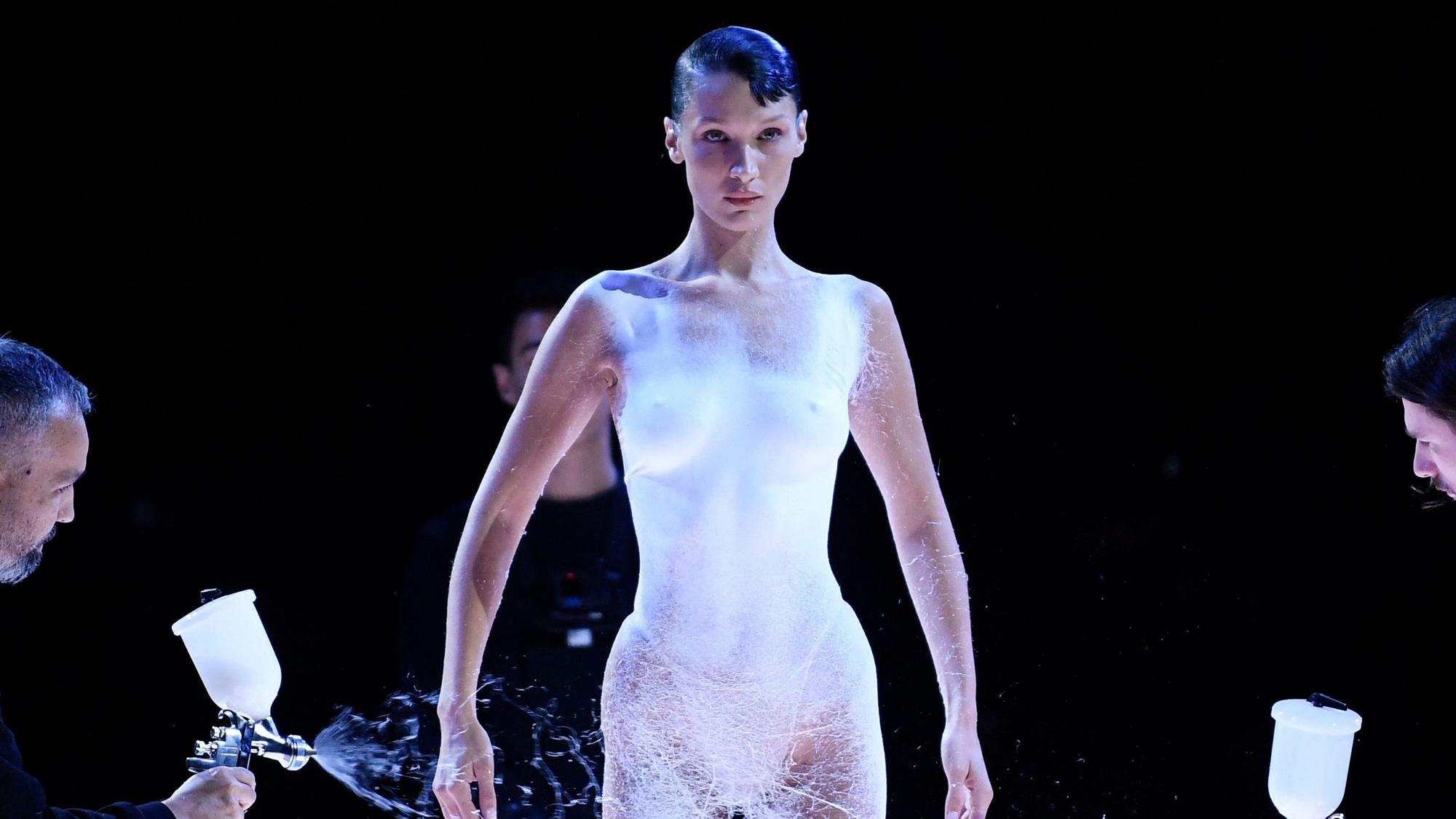 US model Bella Hadid is dressed by spraying foam during the Coperni Spring-Summer 2023 fashion show as part of the Paris Womenswear Fashion Week, in Paris, on September 30, 2022. (Photo by JULIEN DE ROSA / AFP)