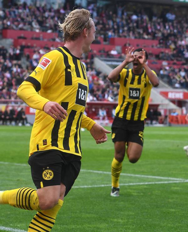 Julian Brandt (v.) feiert sein Tor zum 1:0 für Borussia Dortmund beim 1. FC Köln, Jude Bellingham zelebriert die Führung mit dem Modeste-Jubel.