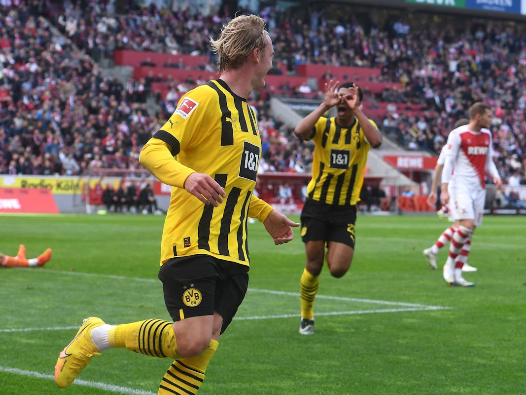 Julian Brandt (v.) feiert sein Tor zum 1:0 für Borussia Dortmund beim 1. FC Köln, Jude Bellingham zelebriert die Führung mit dem Modeste-Jubel.