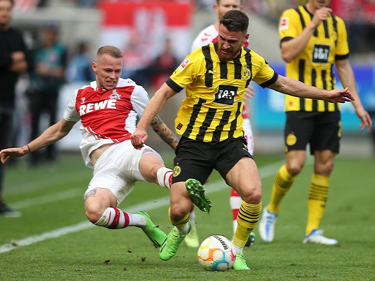 Im Spiel zwischen Köln und Dortmund grätscht Ondrej Duda Salih Özcan von hinten um.