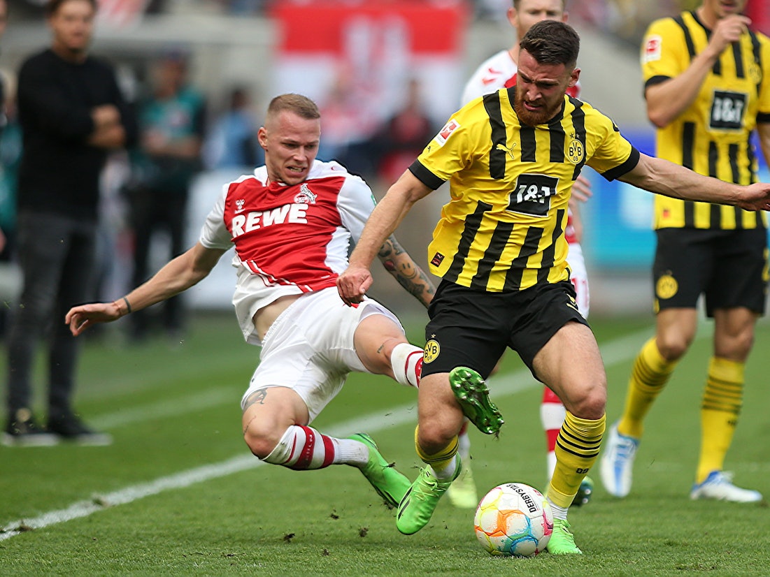 Im Spiel zwischen Köln und Dortmund grätscht Ondrej Duda Salih Özcan von hinten um.