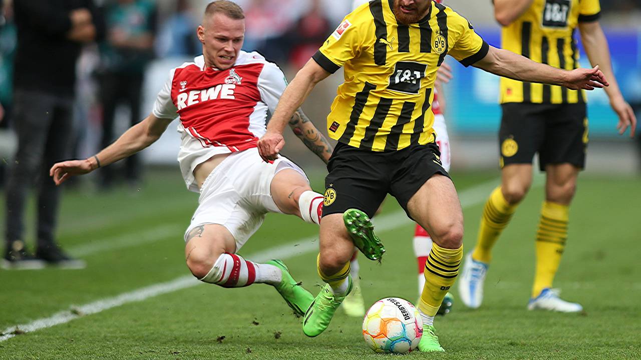 Im Spiel zwischen Köln und Dortmund grätscht Ondrej Duda Salih Özcan von hinten um.