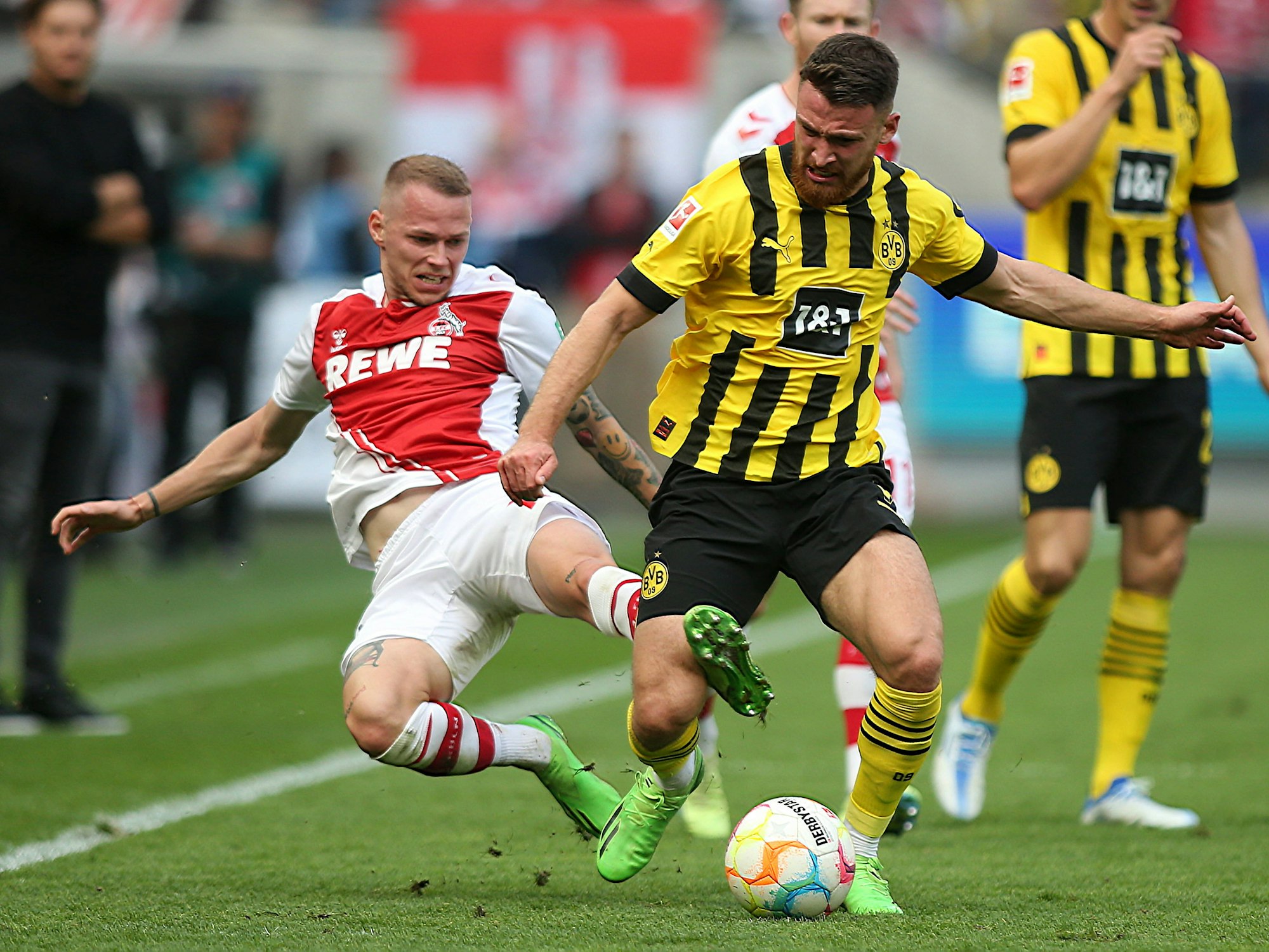 Im Spiel zwischen Köln und Dortmund grätscht Ondrej Duda Salih Özcan von hinten um.