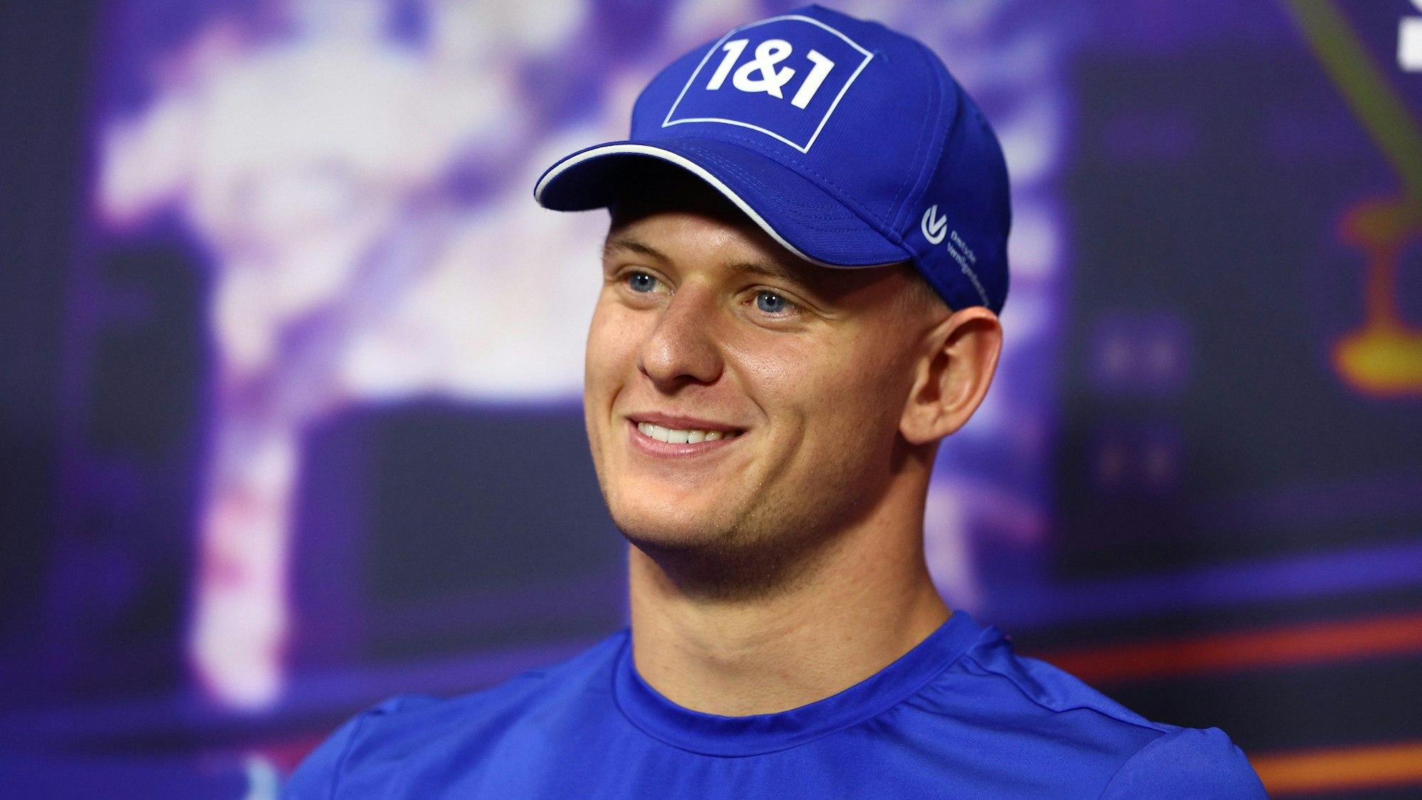 Mick Schumacher mit guter Laune bei einer Pressekonferenz.