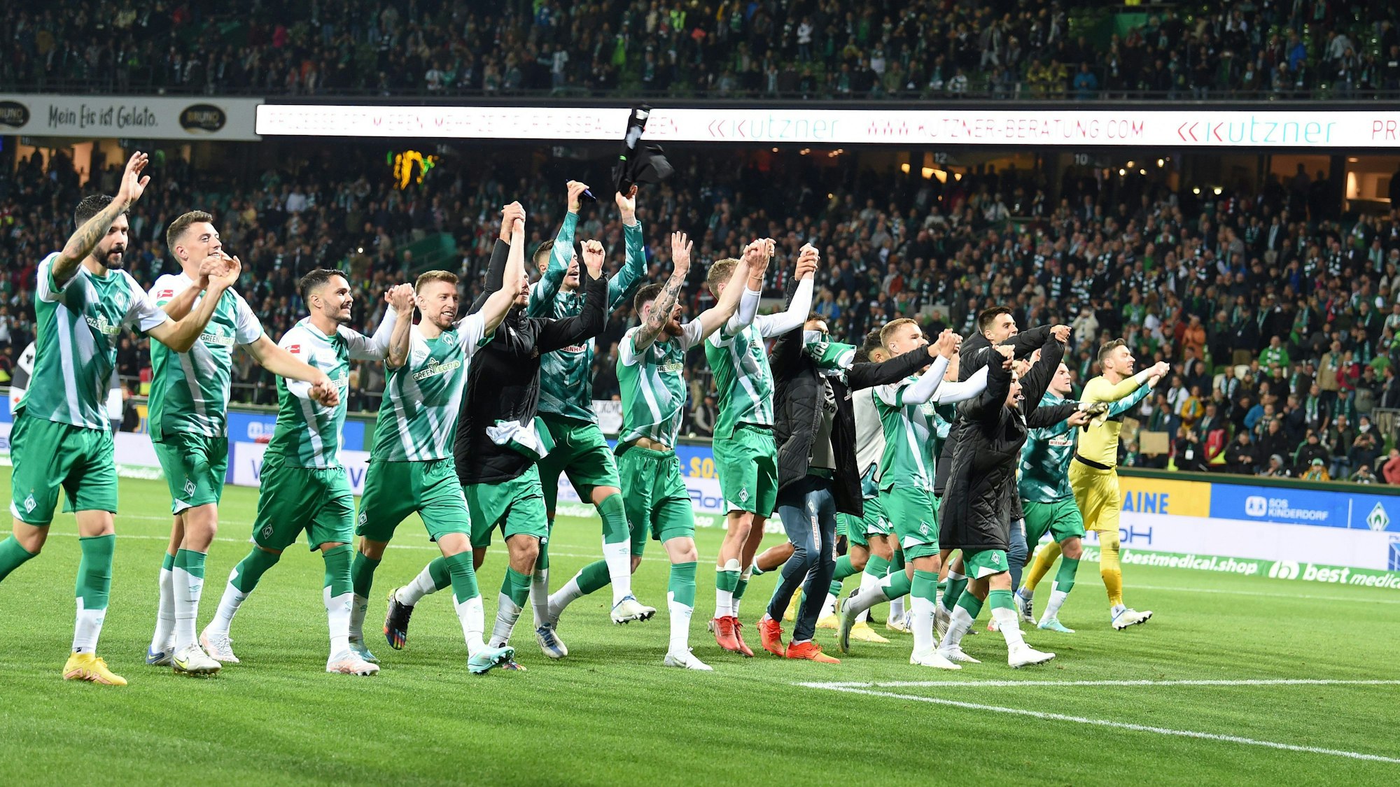 Werders Mannschaft feiert mit den Fans den Sieg.