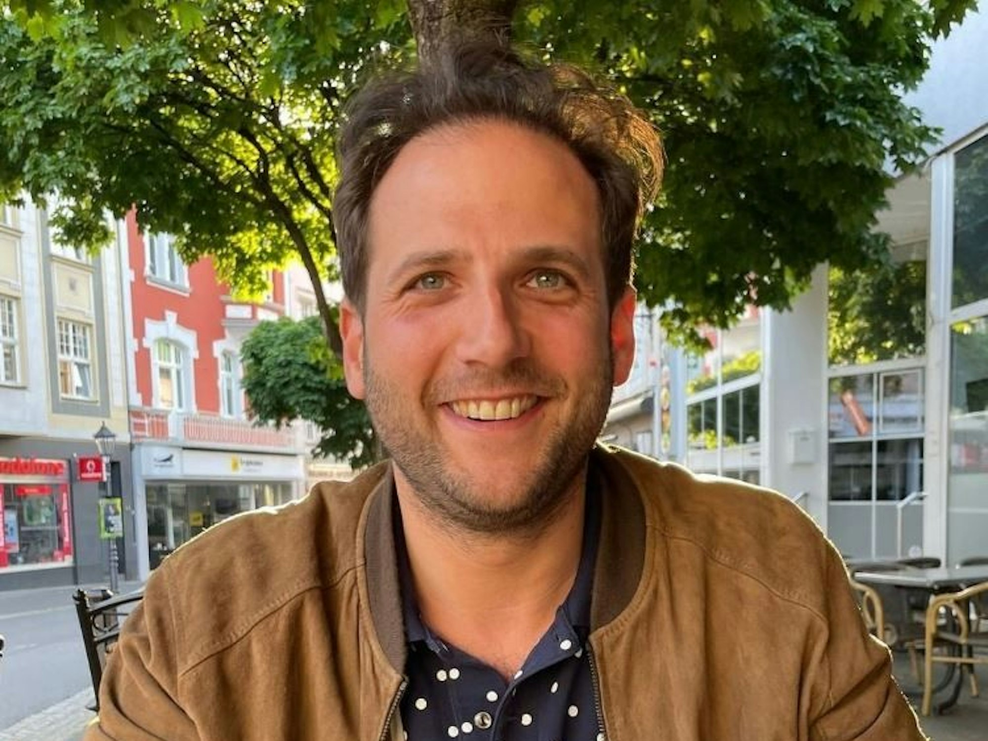 Julian Schmitz-Avila lacht bei Instagram fröhlich in die Kamera.