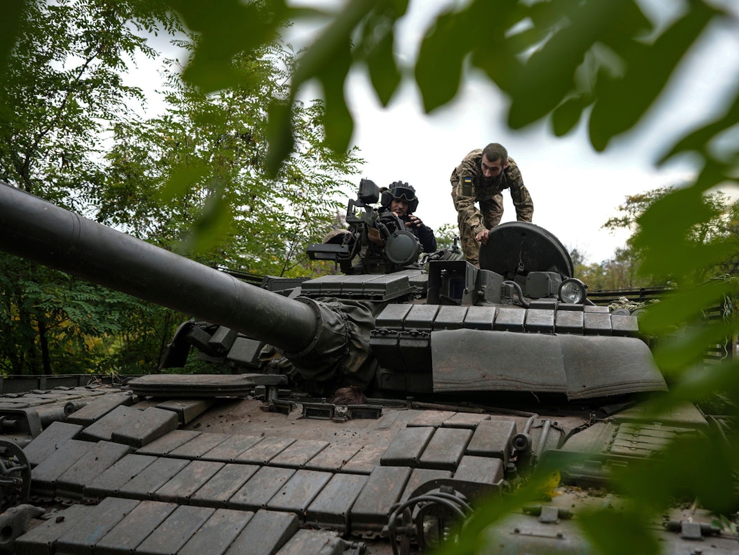 Ukrainische Soldaten stehen auf einem T-80-Panzer, den sie nach eigenen Angaben von der russischen Armee erbeutet haben.