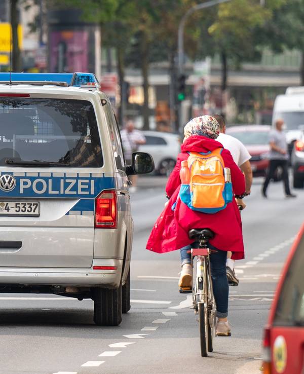 Polizeiauto neben einer Radfahrerin auf der Kalker Hauptstraße.