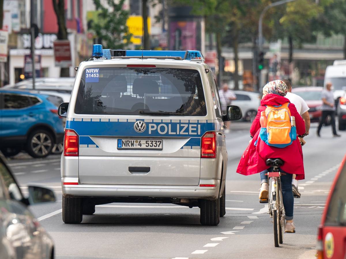 Polizeiauto neben einer Radfahrerin auf der Kalker Hauptstraße.
