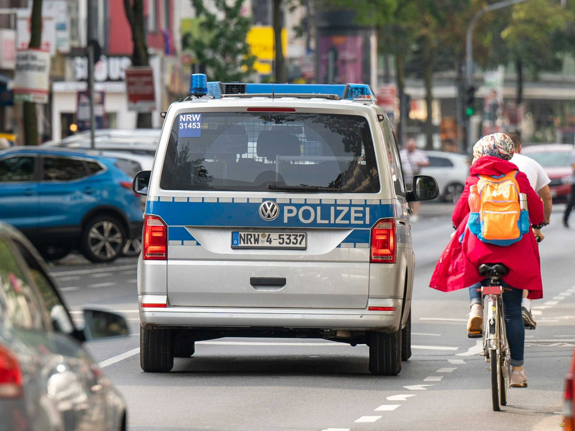 Polizeiauto neben einer Radfahrerin auf der Kalker Hauptstraße.