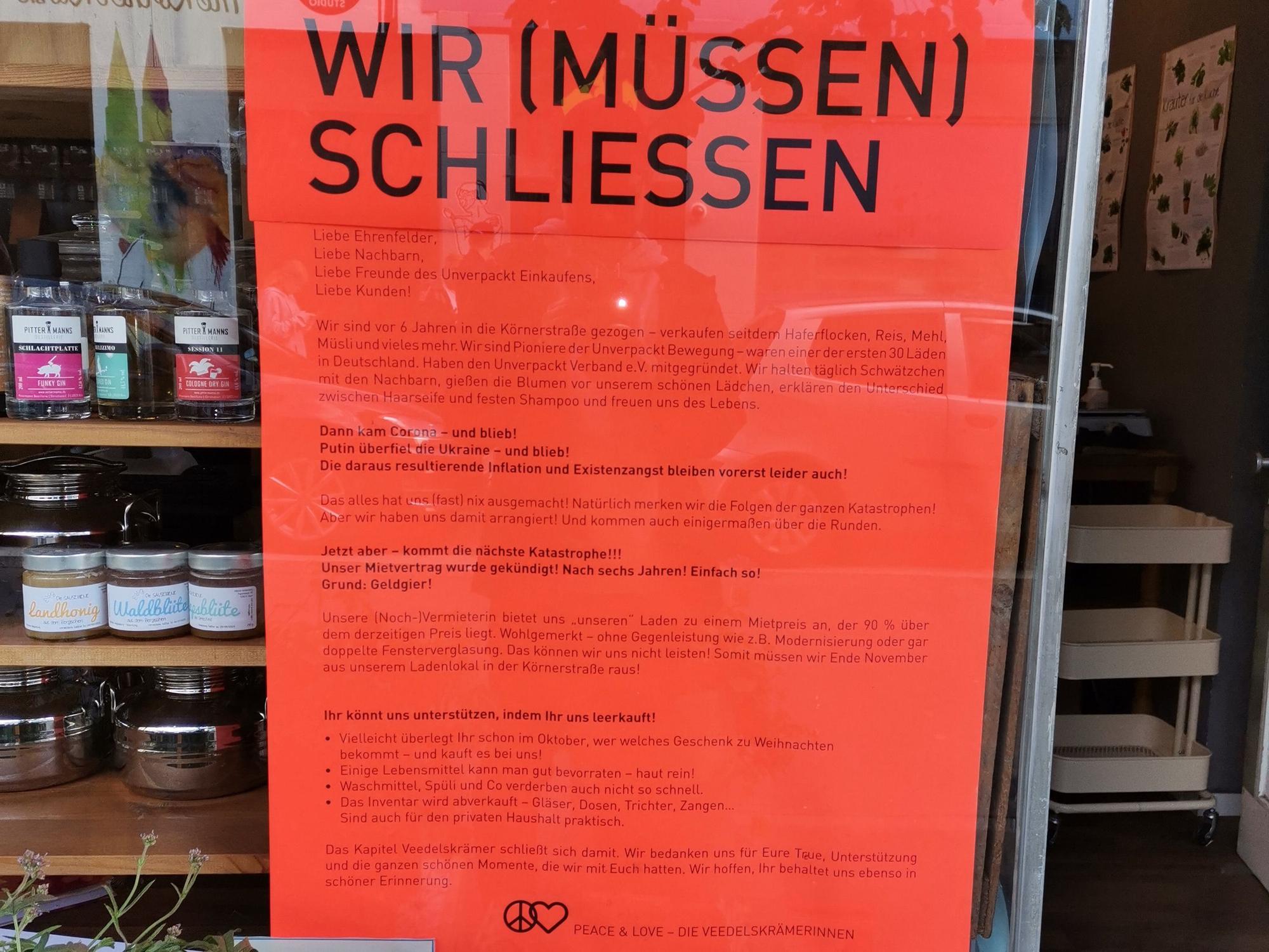 Ein Plakat hängt im Schaufenster des Veedelskrämers in Köln-Ehrenfeld.