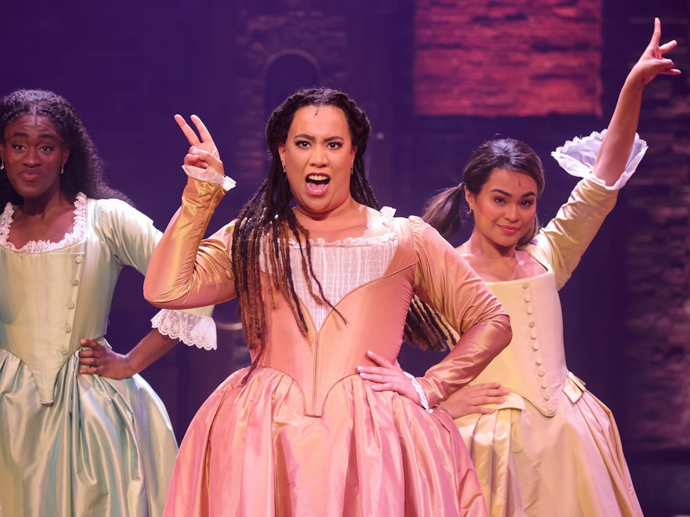 Eine Szene aus dem Musical „Hamilton“, das ab 6. Oktober 2022 in Hamburg aufgeführt wird. Unser Foto zeigt die Musical-Darstellerinnen Ivy Quainoo als als Eliza (v.l.), Chasity Crisp als Angelica, und Mae Ann Jorolan als Peggy.