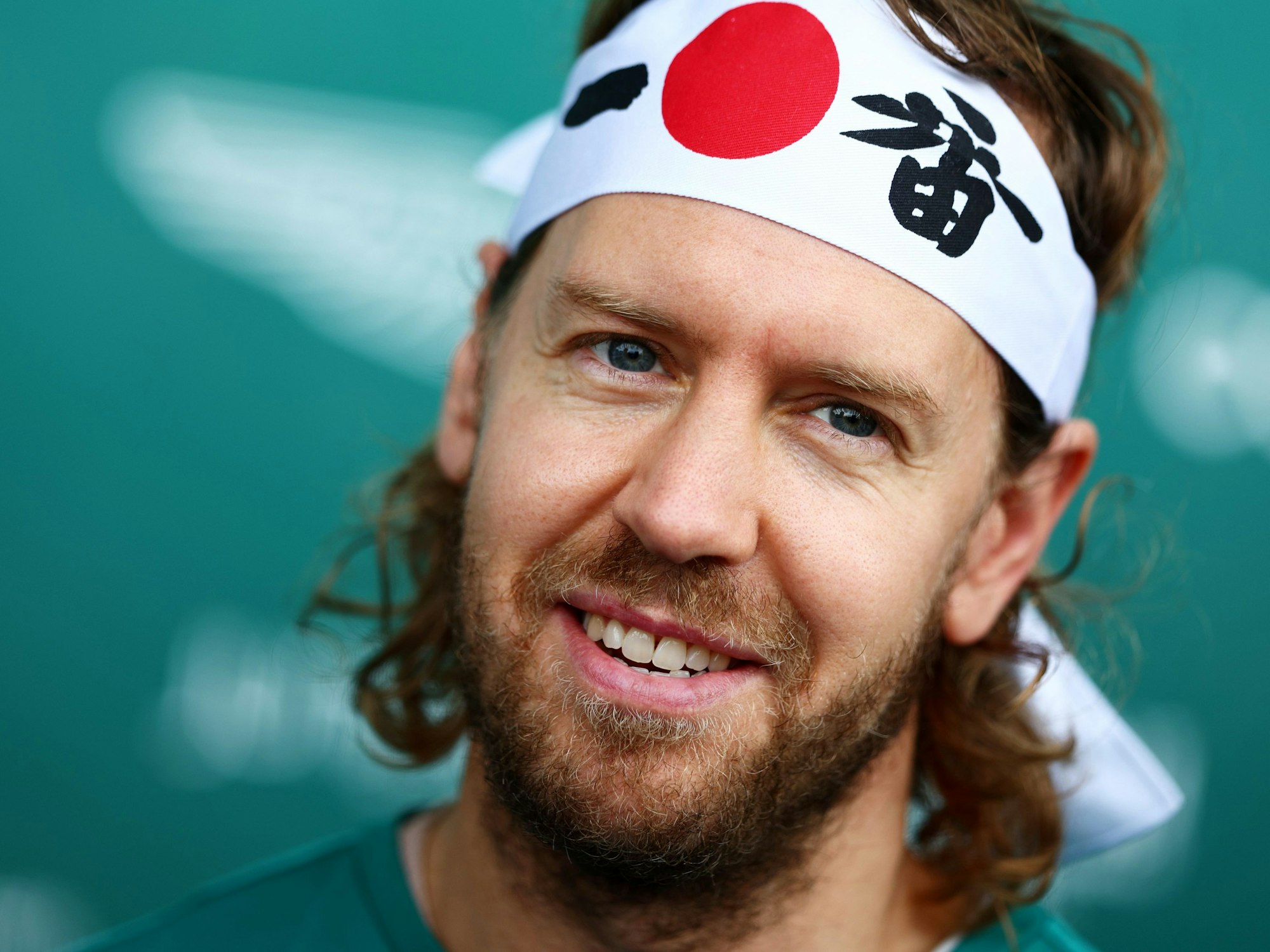 Sebastian Vettel mit Japan-Stirnband auf einer Pressekonferenz.