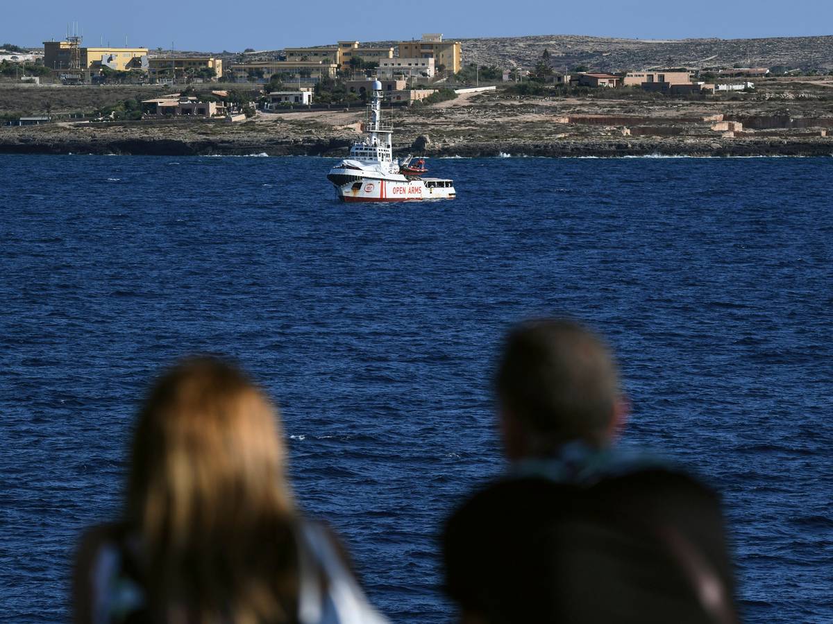 Zwei Menschen auf einer Fähre schauen auf das Rettungsschiff „Open Arms“ der Hilfsorganisation Proactiva. Die Aufnahme dient hier als Symbolfoto.