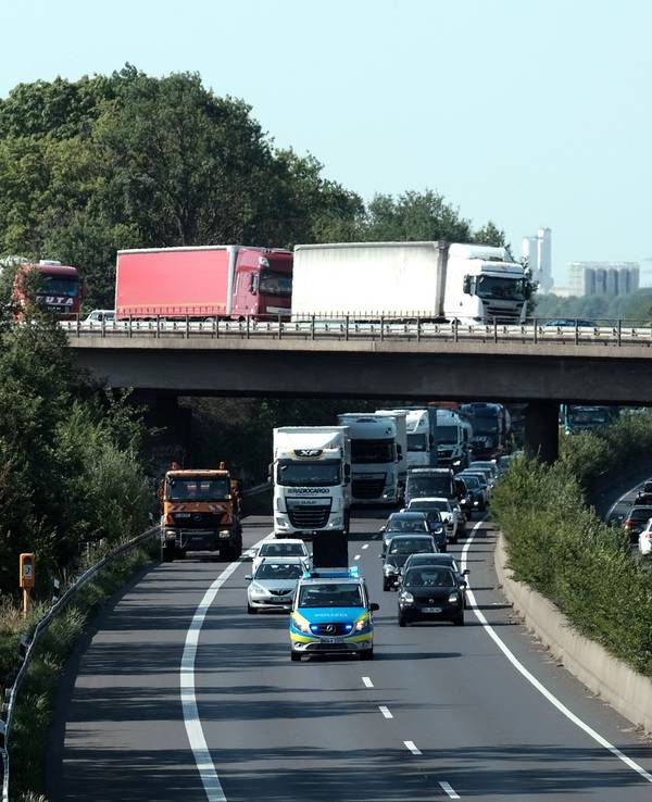 Ein Polizeiauto fährt über die A57. Dahinter fahren weitere Autos.