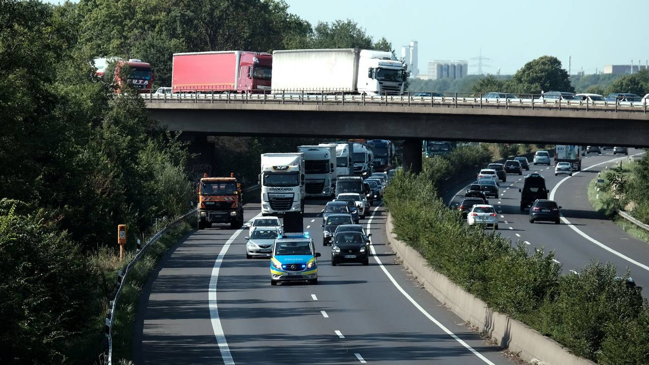 Ein Polizeiauto fährt über die A57. Dahinter fahren weitere Autos.