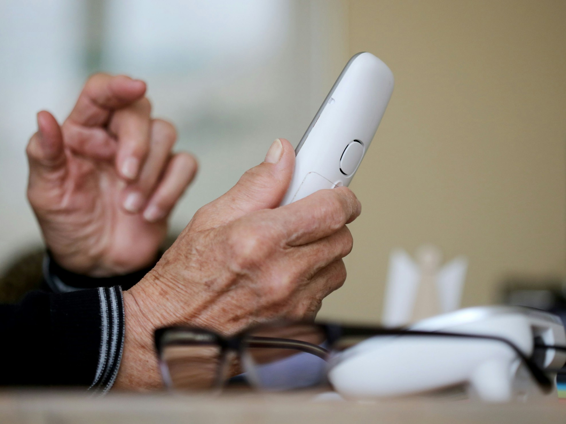 Eine ältere Dame nimmt in ihrer Wohnung ein Telefongespräch an.