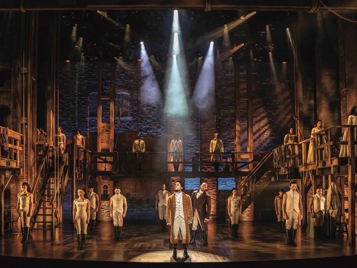 Die Kulisse und einige der Darsteller und Darstellerinnen des Musicals „Hamilton“, welches ab dem 6. Oktober in Hamburg besucht werden kann.