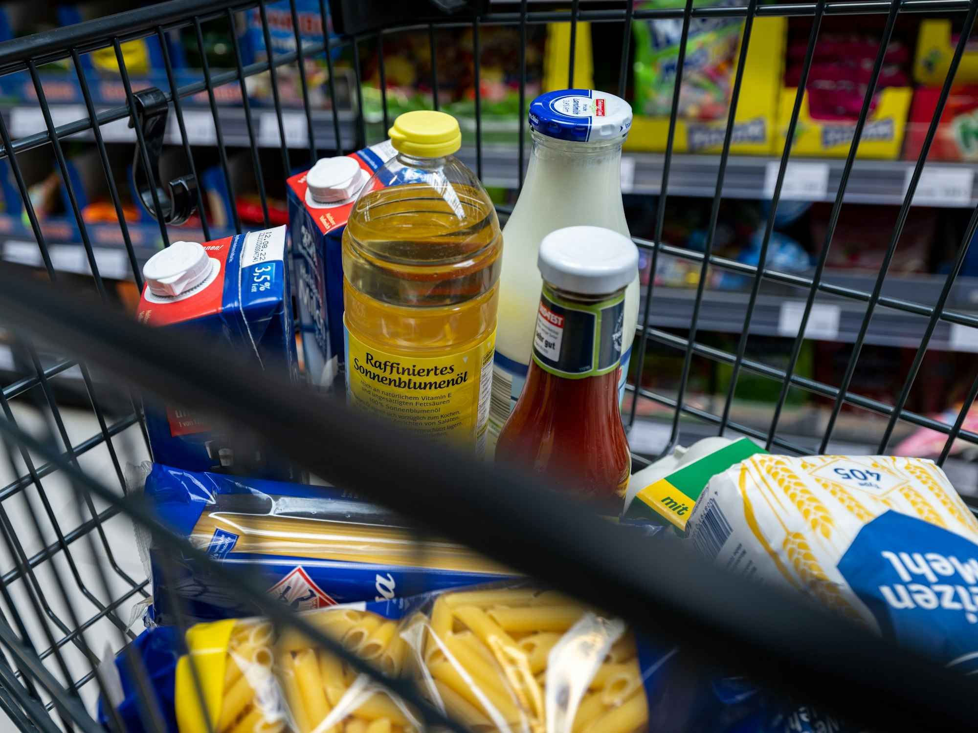 Lebensmittel liegen in einem Einkaufswagen in einem Supermarkt.