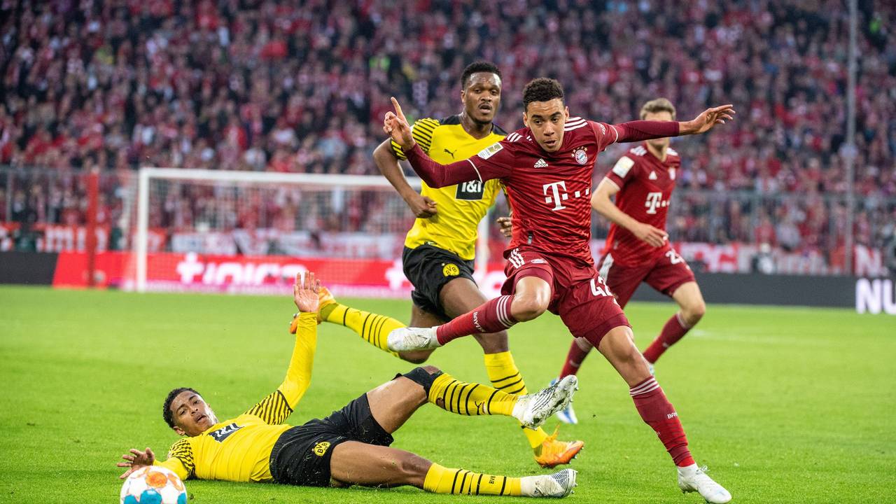 Dan-Axel Zagadou von Borussia Dortmund (M), Jamal Musiala vom FC Bayern München (r.) und Jude Bellingham von Borussia Dortmund (unten) im Kampf um den Ball im Duell Bayern gegen den BVB.
