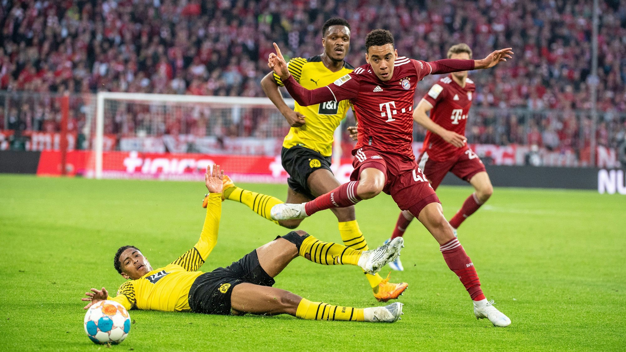Dan-Axel Zagadou von Borussia Dortmund (M), Jamal Musiala vom FC Bayern München (r.) und Jude Bellingham von Borussia Dortmund (unten) im Kampf um den Ball im Duell Bayern gegen den BVB.