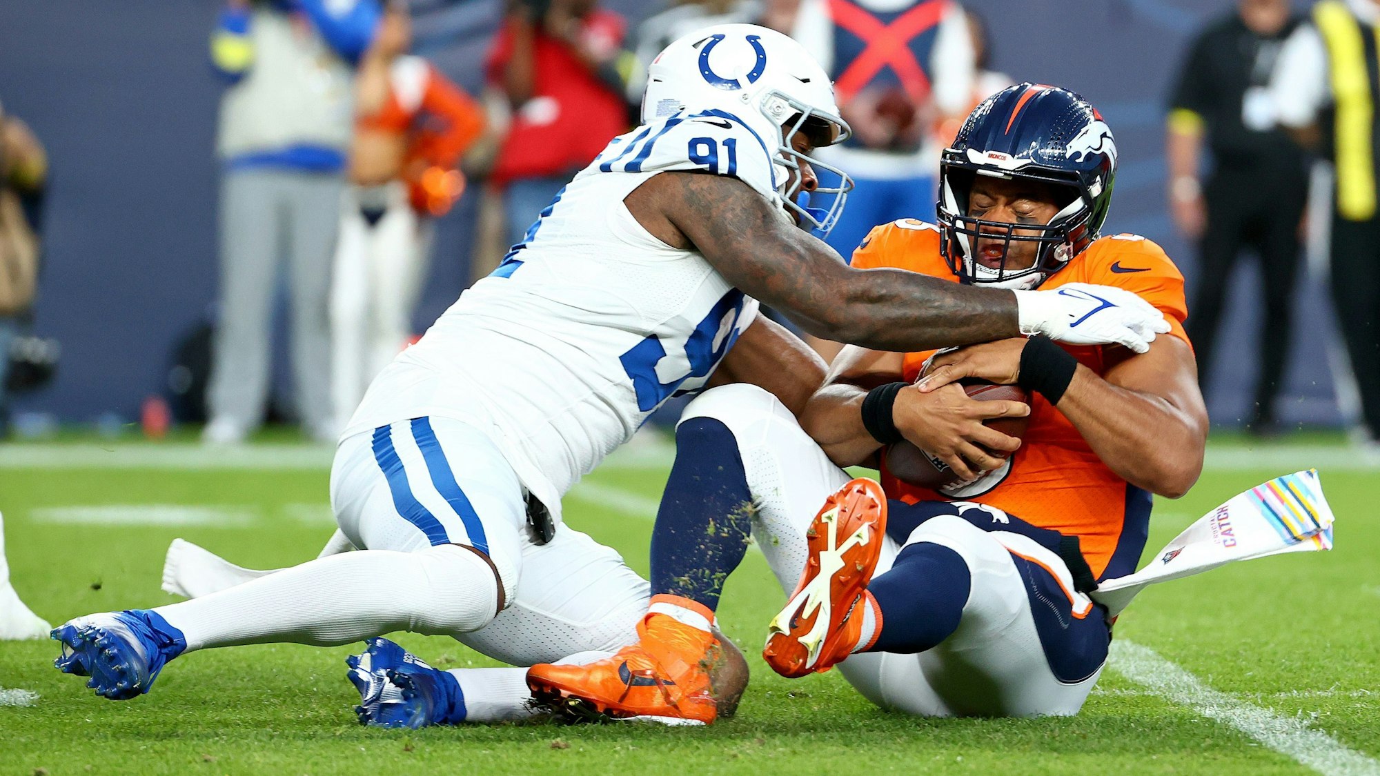 Russell Wilson von den Denver Broncos wird von Yannick Ngakouevon den Indianapolis Colts gestoppt.