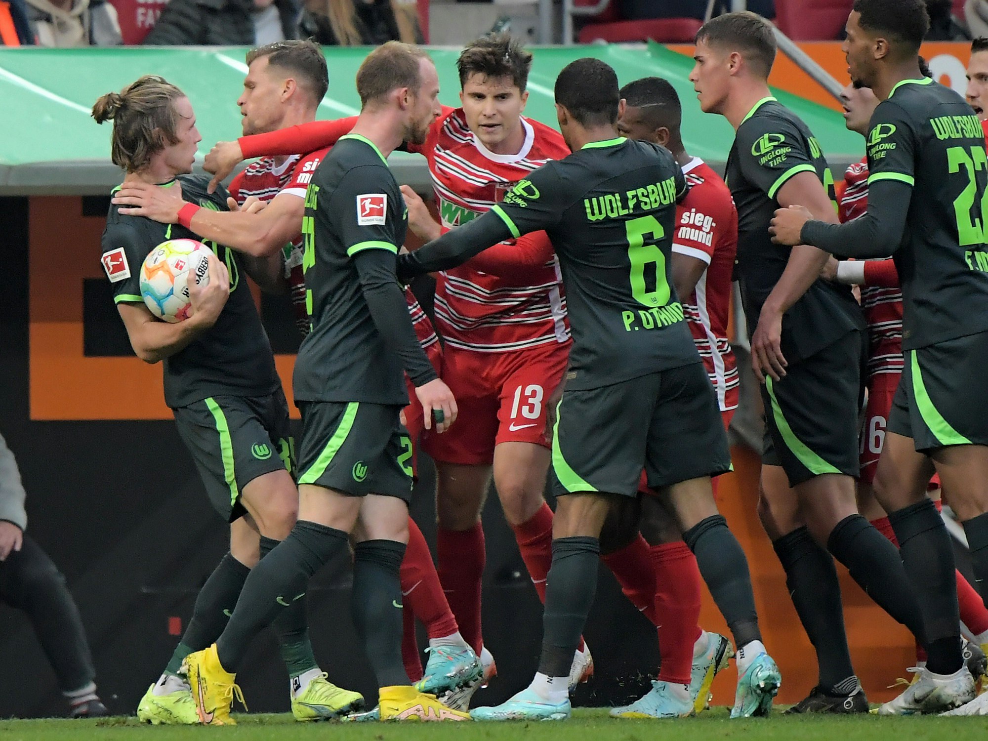 Die Spieler des FC Augsburg und des VfL Wolfsburg in einer Rudelbildung.