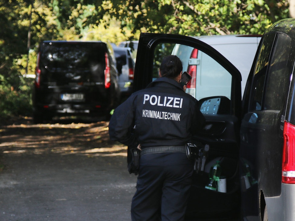 Eine Kriminaltechnikerin steht in der Nähe vom S-Bahnhof Hohenschönhausen neben Fahrzeugen der Polizei. Bislang haben aber weder die Bahn noch die Polizei betätigt, dass der abgebildete Einsatz in Hohenschönhausen im Zusammenhang mit den Sabotageakten steht.