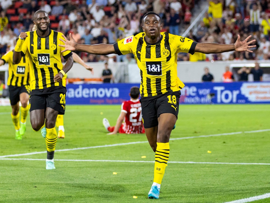 Youssoufa Moukoko (r.) jubelt mit weit ausgestreckten Armen nach seinem Tor.