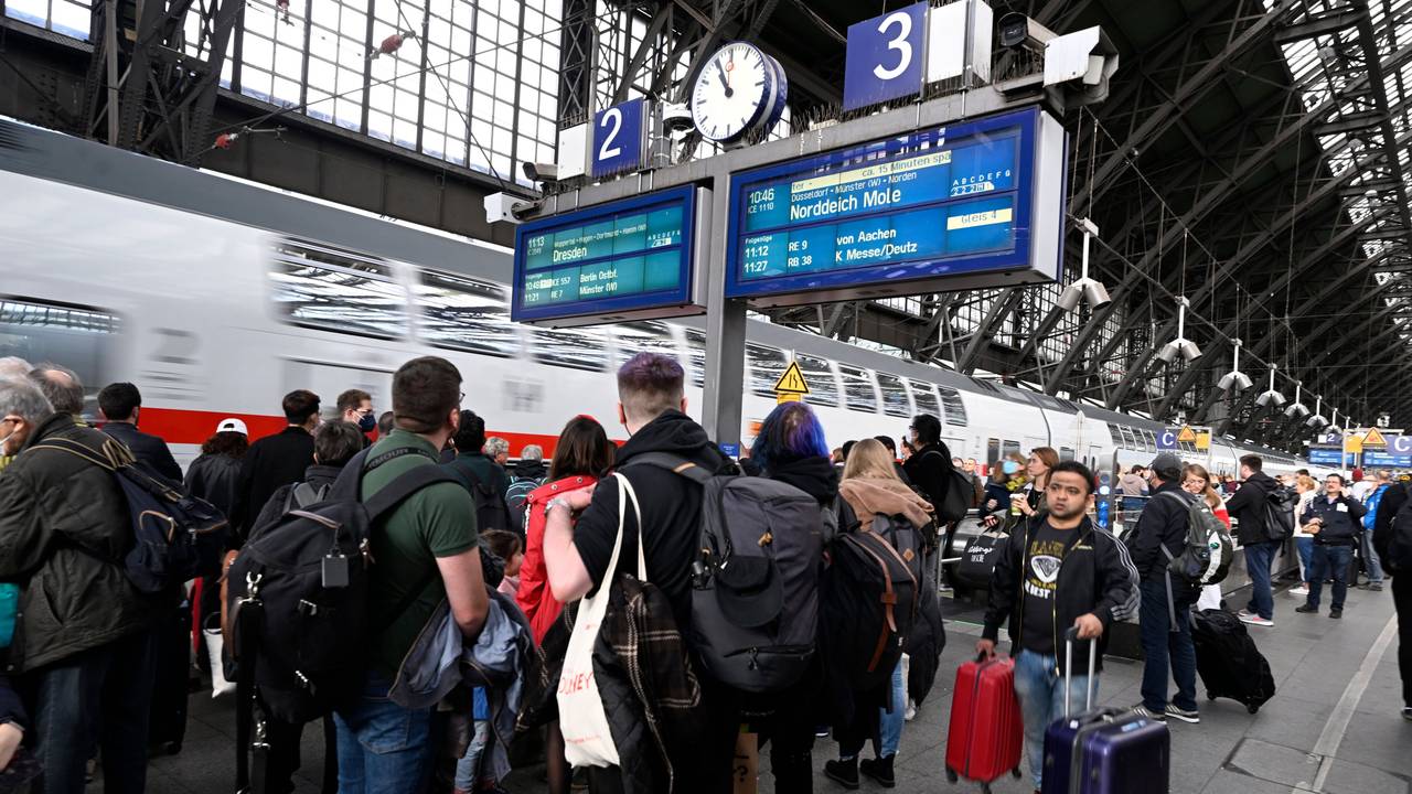 Reisende stehen am Hauptbahnhof und warten auf ihre Weiterfahrt.