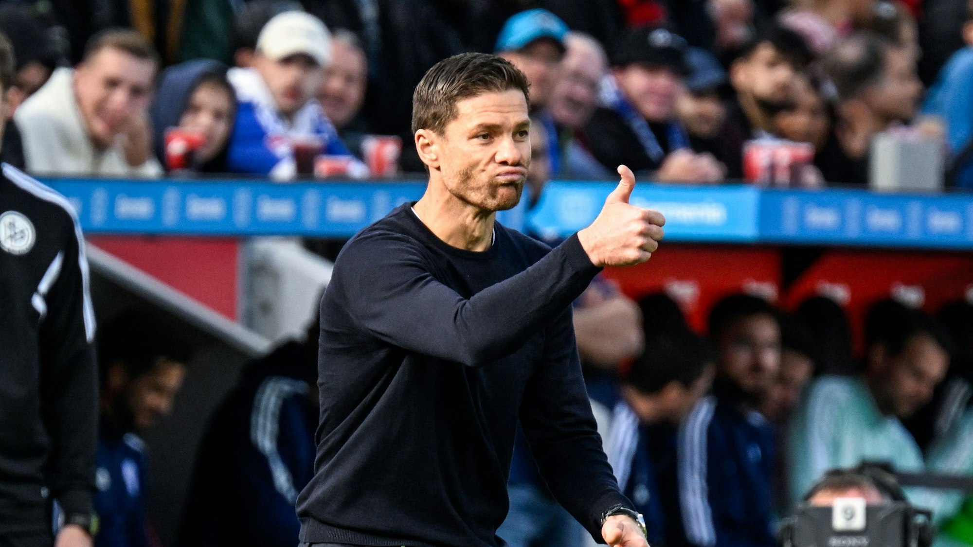 Leverkusens Trainer Xabi Alonso hebt im Spiel gegen den FC Schalke 04 an der Seitenlinie den Daumen
