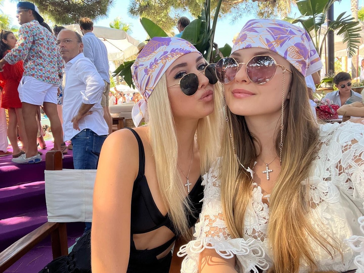 Shania und Davina posieren mit pinken Kopftüchern und Sonnenbrillen für ein Selfie.