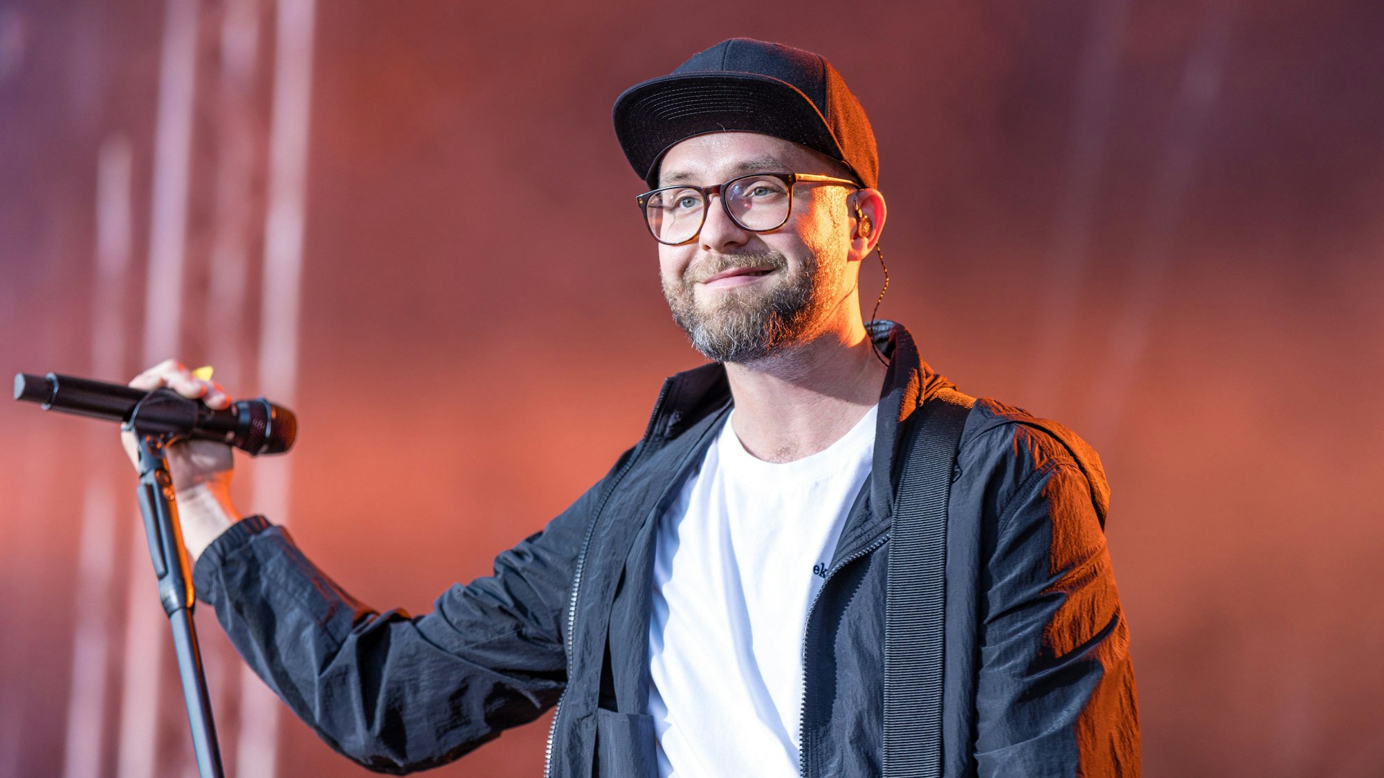 Der Sänger Mark Forster steht bei einem Konzert auf der Bühne.