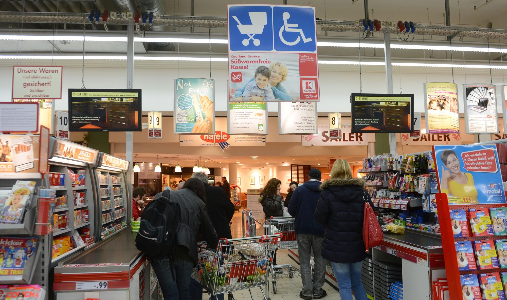 Kundinnen und Kunden stehen im Kassenbereich einer Kaufland-Filiale in der Schlange.