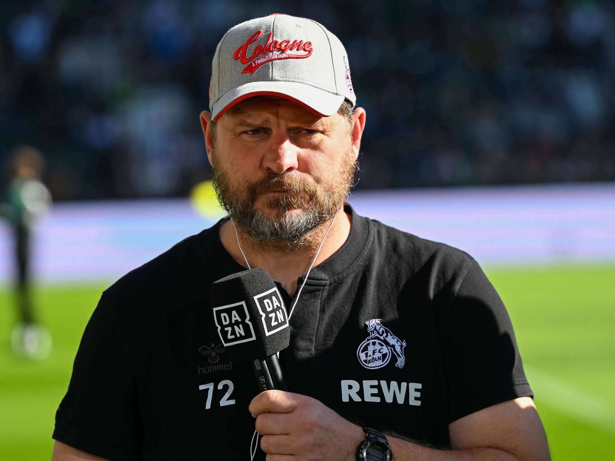 Steffen Baumgart mit DAZN-Mikrofon in der Hand.