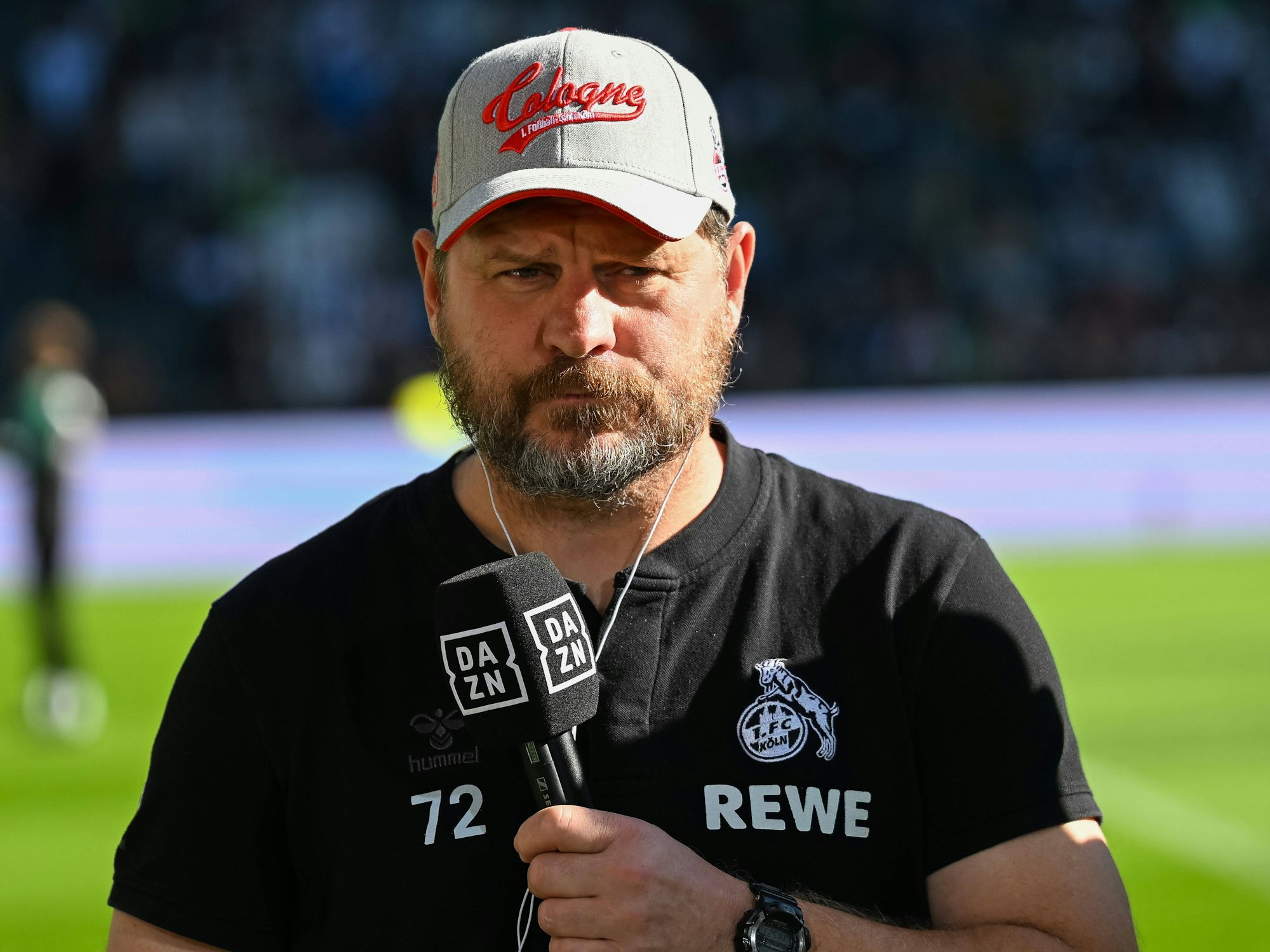 Steffen Baumgart mit DAZN-Mikrofon in der Hand.