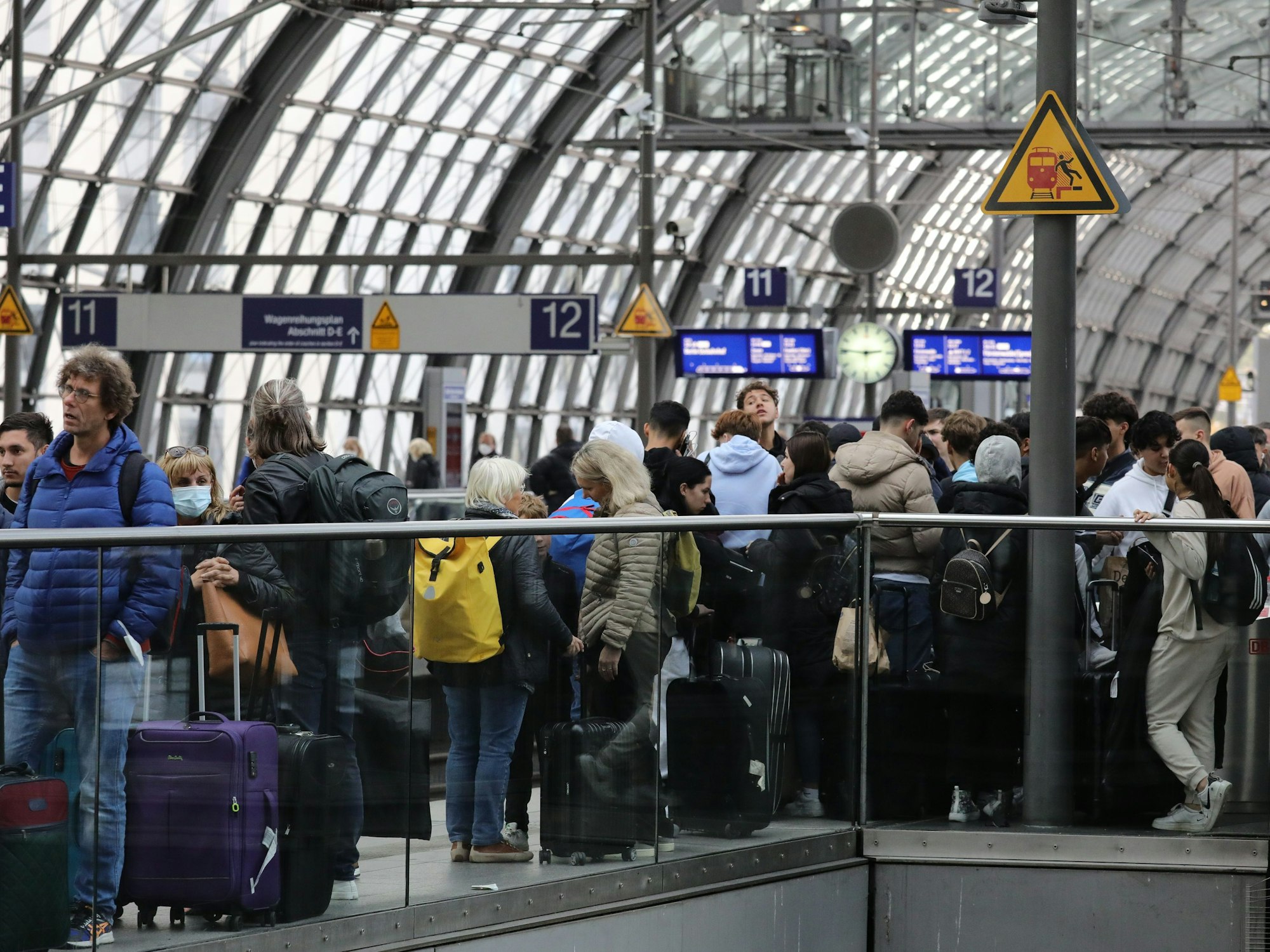 Reisende stehen auf einem Gleis am Berliner Hauptbahnhof.
