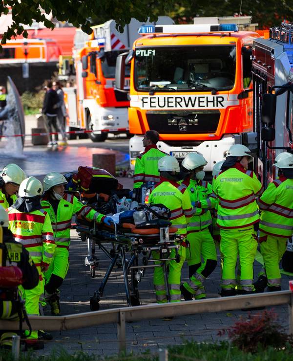 Rettungskräfte stehen am Samstag (8. Oktober 2022) während der Löscharbeiten am U-Bahnhof Ebertplatz in Köln.