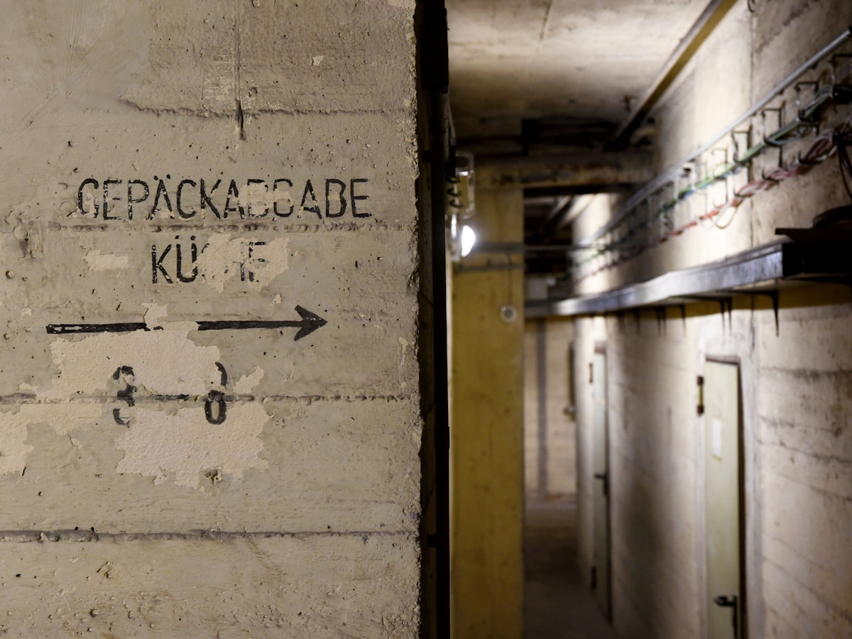 Blick in den Kölner Hochbunker am Kölner Hauptbahnhof – auf der Mauer steht „Gepäckabgabe“ und „Küche“.