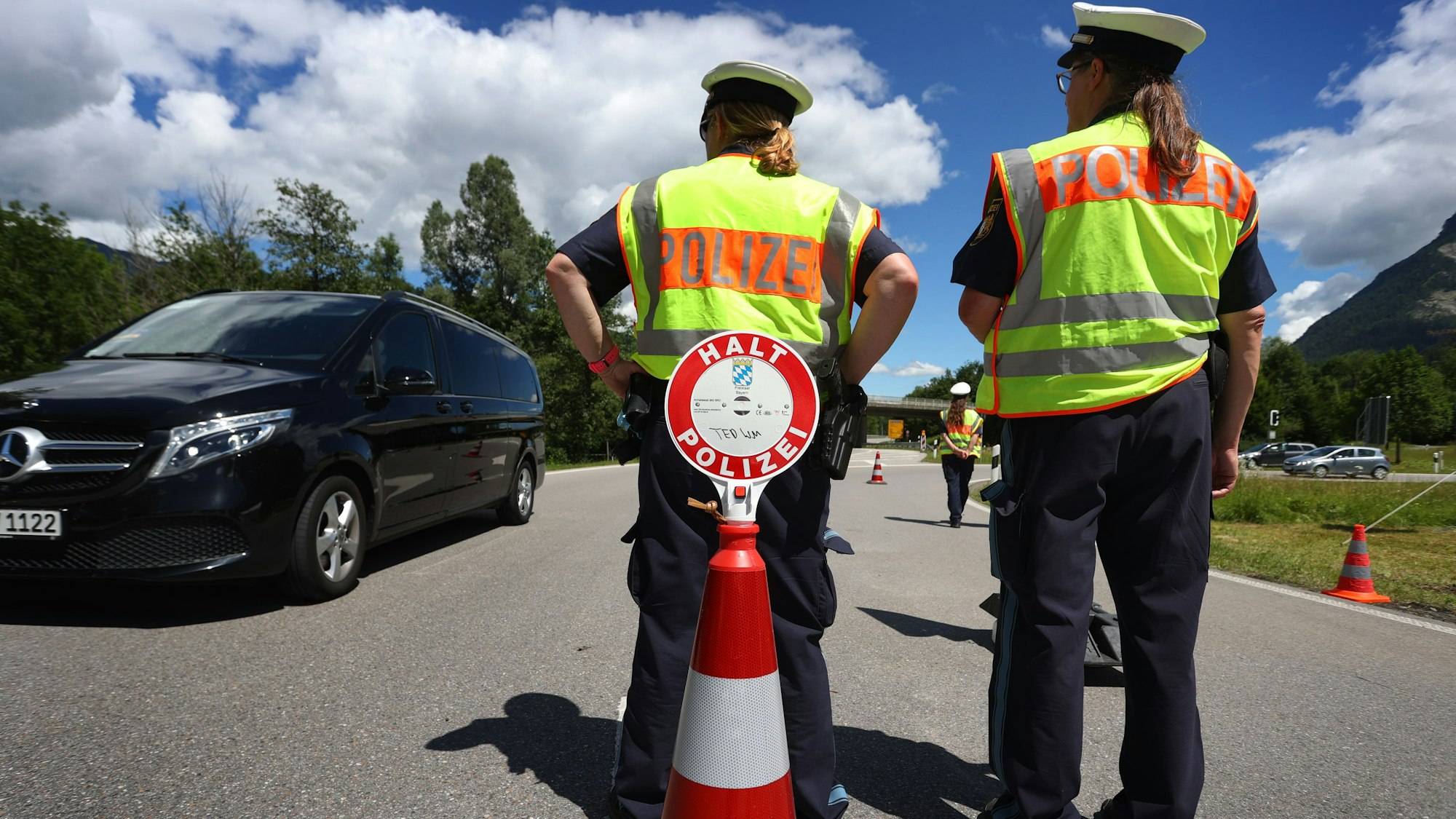 Polizisten stehen bei einer Verkehrskontrolle am Ortseingang.