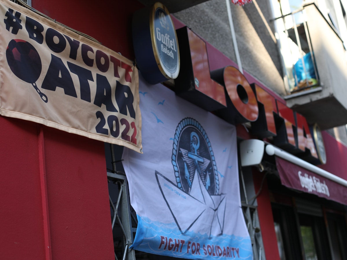 Über der Bar "Lotta" hängt ein Plakat mit dem Hinweis, dass die WM in Karar boykottiert wird.