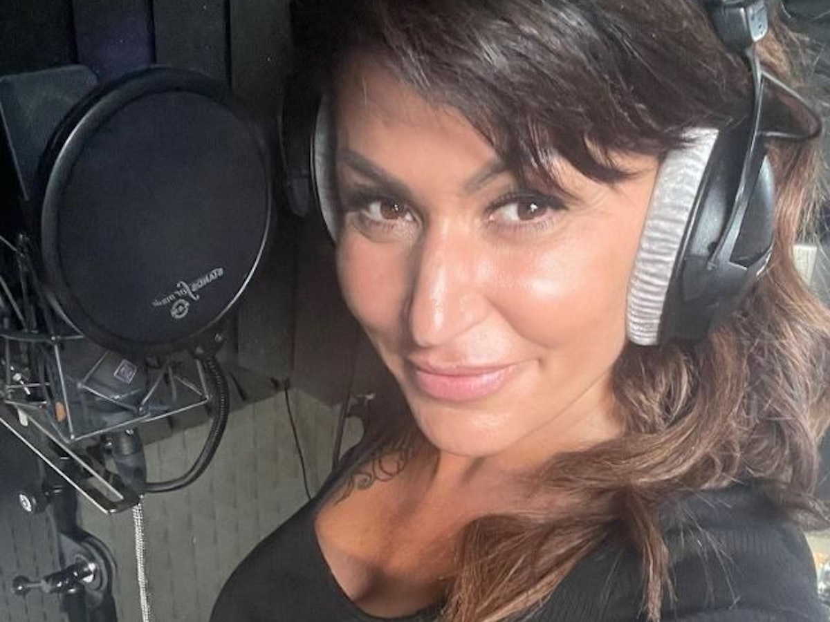 Jasmin Herren steht mit Kopfhören vor einem Mikrofon.