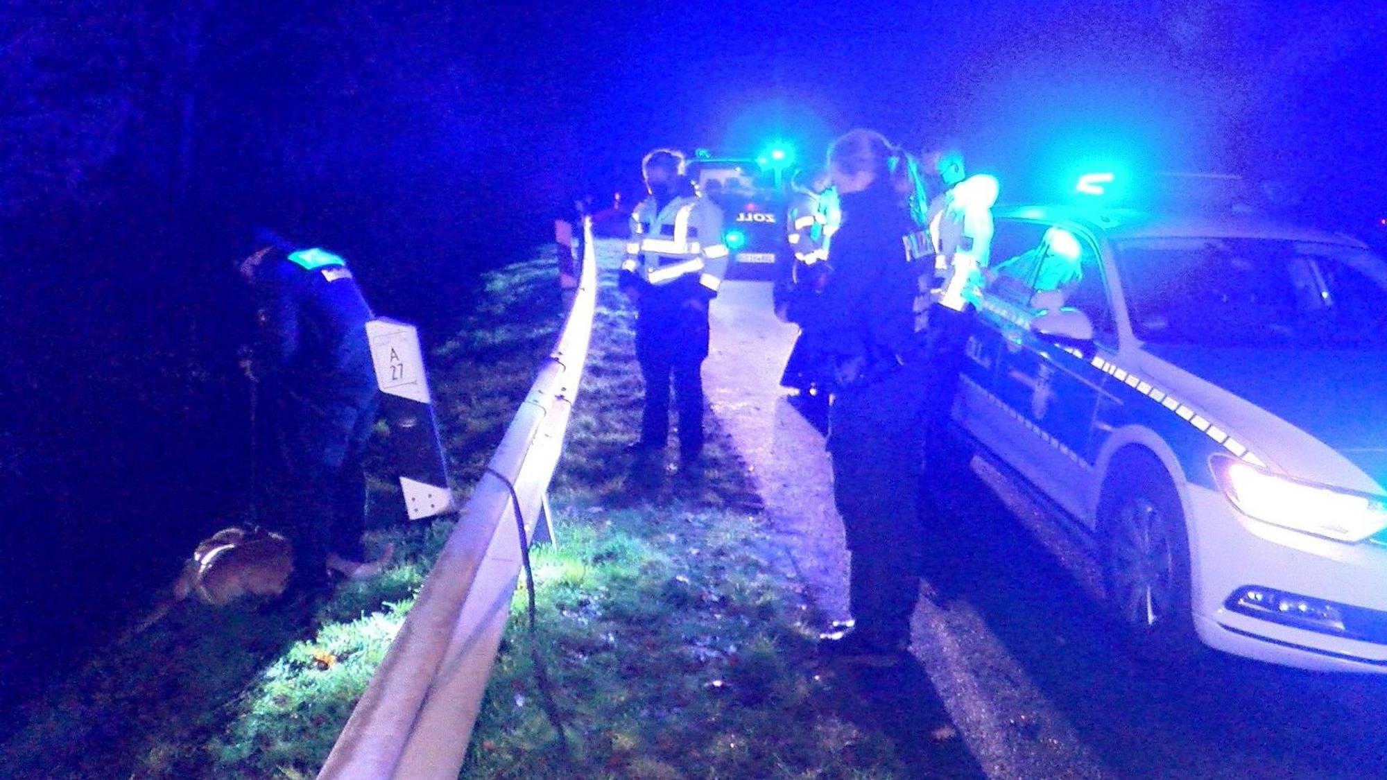 Einsatzkräfte der Polizei stehen an einer Leitplanke.